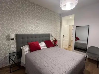 a bedroom with a bed with red pillows and a mirror at MARITZA Guest House 2 in Rome
