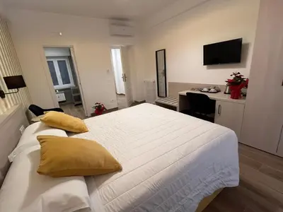 a bedroom with a large white bed with yellow pillows at MARITZA Guest House 2 in Rome