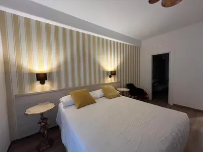 a bedroom with a large white bed with yellow pillows at MARITZA Guest House 2 in Rome