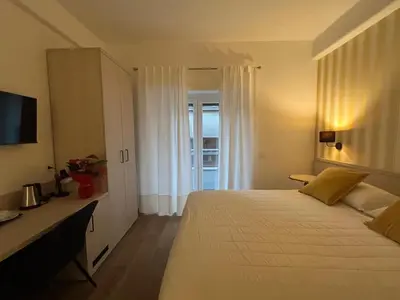 a bedroom with a large white bed and a window at MARITZA Guest House 2 in Rome