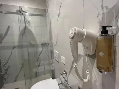 a blow dryer on a wall in a bathroom at MARITZA Guest House 2 in Rome