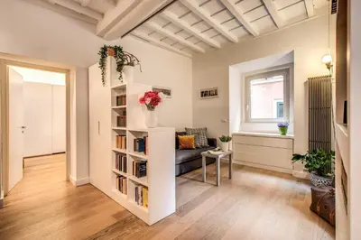 a living room with a book shelf and a couch at Orange Suites in Rome