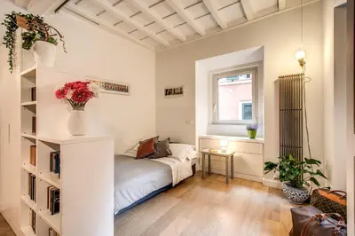 a bedroom with a bed and a vase of flowers at Orange Suites in Rome