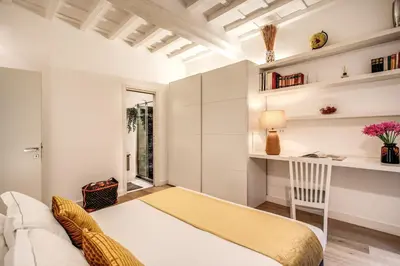 a bedroom with a bed and a desk and a window at Orange Suites in Rome