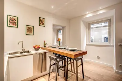 a kitchen with a sink and a counter with stools at Orange Suites in Rome