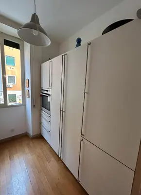 a kitchen with a large white refrigerator in a room at GeNa Home, a due passi da San Giovanni in Rome
