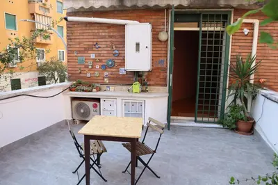 an outdoor kitchen with a table and chairs on a patio at GeNa Home, a due passi da San Giovanni in Rome