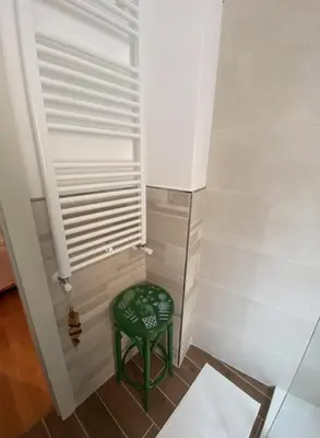 a small room with a green stool next to a window at GeNa Home, a due passi da San Giovanni in Rome