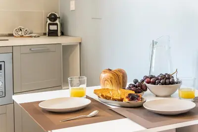 a table with a bowl of fruit and a bowl of orange juice at Collection39 Scipioni Luxury Apartment in Rome