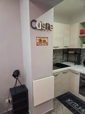 a kitchen with white cabinets and a sign on the wall at Barbara House Monteverde in Rome
