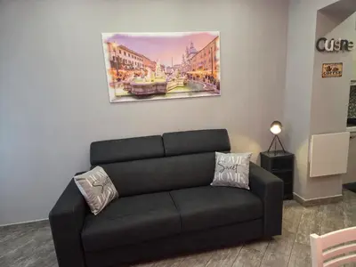 a couch in a living room with a painting on the wall at Barbara House Monteverde in Rome