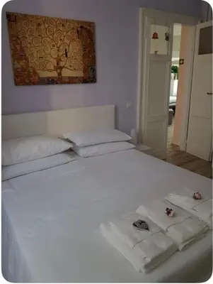 a white bed with two towels on top of it at LaReginetta in Rome