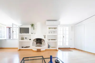 a living room with a fireplace in the middle at Casa Mia - Trastevere Rooftop Nest in Rome
