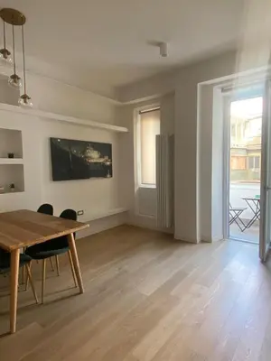 an empty living room with a wooden table and chairs at Golden Suite in Rome