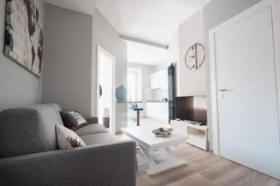 a living room with a couch and a table and a clock at La Perla dell'Appia in Rome