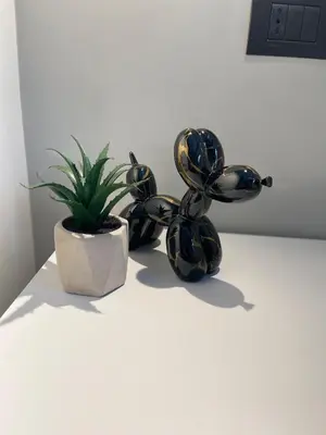 two black sculptures sitting next to a potted plant at La Perla dell'Appia in Rome