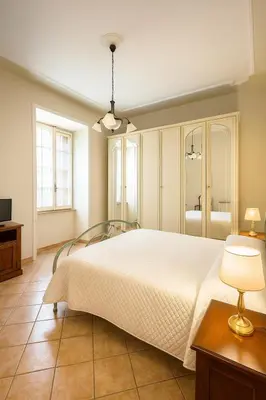 a bedroom with a large white bed and a television at Colosseo Rooms Apartments in Rome