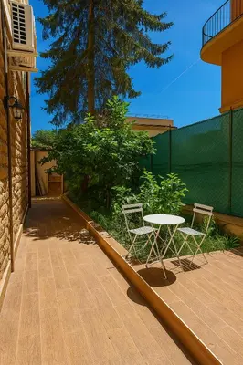 a patio with two chairs and a table on a deck at Colosseo Rooms Apartments in Rome