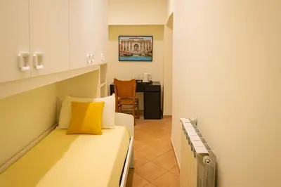 a small room with a bed and a desk at Colosseo Rooms Apartments in Rome