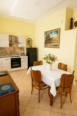 a kitchen with a table with a vase of flowers on it at Colosseo Rooms Apartments in Rome