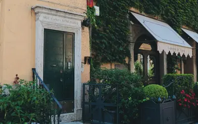 a house with a black door and some plants at Biscione Dream Campo de'Fiori in Rome