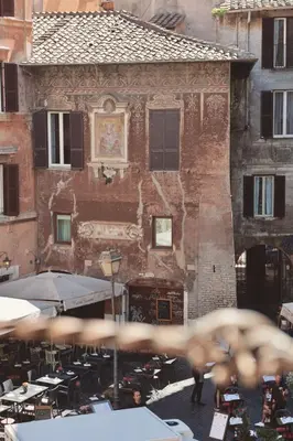 an old building with tables and chairs in front of it at Biscione Dream Campo de'Fiori in Rome
