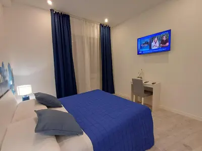 a bedroom with a bed and a desk and a television at Lux Urbis Pio VIII in Rome