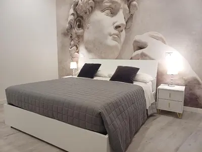 a bedroom with a bed with a large painting on the wall at Lux Urbis Pio VIII in Rome