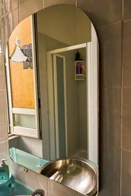 a mirror above a sink in a bathroom at PP Stanza Privata in Appartamento Pigneto in Rome