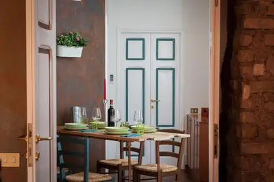 a dining room table with chairs and wine glasses at Argilla Apartment in Rome