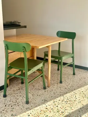 a wooden table and two green chairs sitting around it at Ai Parrocchetti, Loft con Terrazza Panoramica in Rome