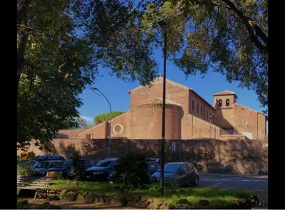 a large brick building with cars parked in a parking lot at Charme Holidays San Saba in Rome
