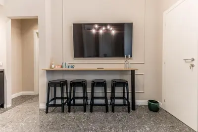 a bar with three stools and a television on a wall at APT ROME - Guest House Casini 6 Trastevere in Rome