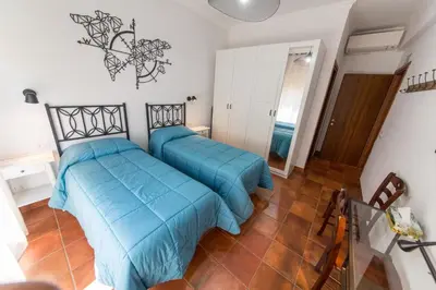 two beds in a room with blue sheets at wonderful apartment in Rome