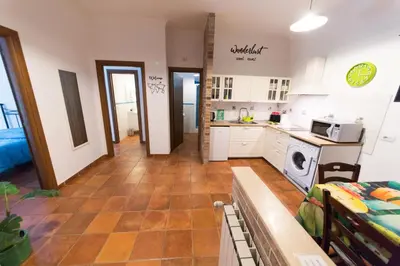 a kitchen and living room with white cabinets and a table at wonderful apartment in Rome