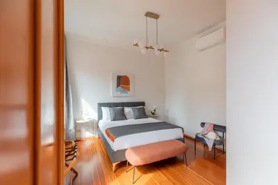 a bedroom with a bed and a chair and a mirror at iFlat Spanish Steps Chic & Warming Hideaway in Rome