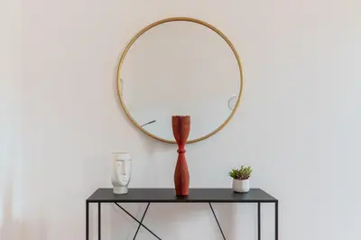 a table with a round mirror on a wall at iFlat Spanish Steps Chic & Warming Hideaway in Rome