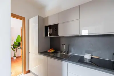 a kitchen with white cabinets and a sink at iFlat Spanish Steps Chic & Warming Hideaway in Rome
