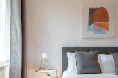 a bedroom with a bed and a table with a lamp at iFlat Spanish Steps Chic & Warming Hideaway in Rome