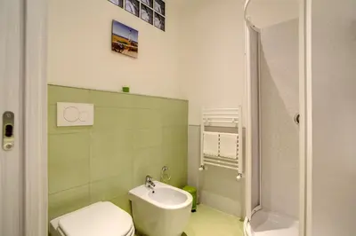 a bathroom with a white toilet and a sink at Vatican Rooms Cipro in Rome