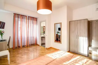 a living room with a large window and a wooden floor at Vatican Rooms Cipro in Rome