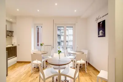 a dining room with four tables and white chairs at Vatican Rooms Cipro in Rome