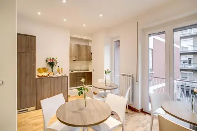a kitchen and dining room with two tables and chairs at Vatican Rooms Cipro in Rome