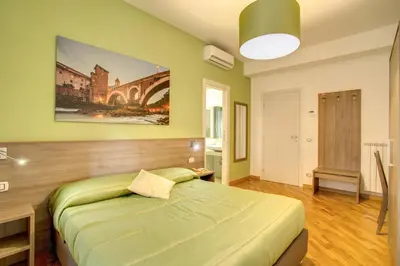 a bedroom with a large green bed in it at Vatican Rooms Cipro in Rome