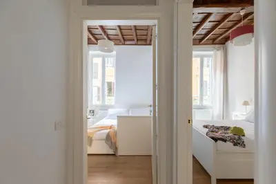 a white bedroom with a bed and a window at iFlat Monti Charming & Cozy Apt by the Colosseum in Rome