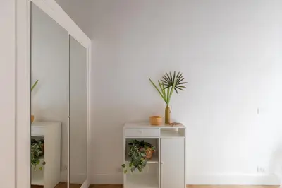 a white cabinet with a plant on it next to a mirror at iFlat Monti Charming & Cozy Apt by the Colosseum in Rome