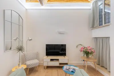 a living room with a tv and a couch and a chair at iFlat Monti Charming & Cozy Apt by the Colosseum in Rome