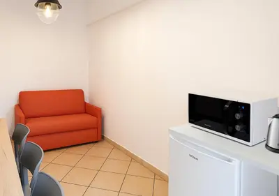 a living room with a red chair and a tv at Irpinia 19 Guest House in Rome