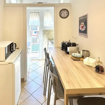 a kitchen with a table with chairs and a microwave at Irpinia 19 Guest House in Rome