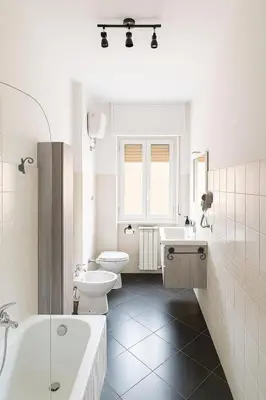 a white bathroom with a tub and a toilet and a sink at Irpinia 19 Guest House in Rome